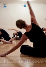 Class of dancers sitting, stretching side. Photo by Savage Rose Photography
