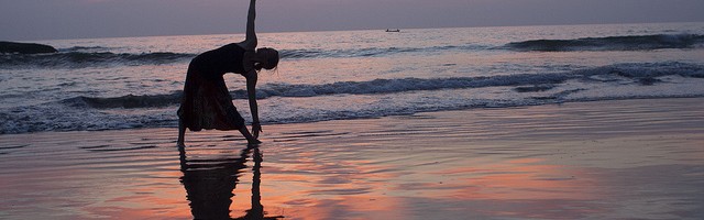 Woman practicing yoga on beach