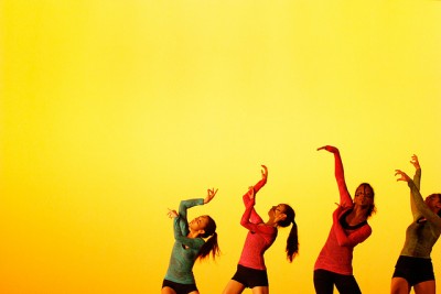 Four teen dancers lift their arms