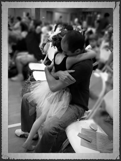 A father and daughter share a hug at dance recital