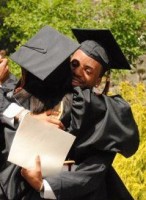 IMAGE Roger Lee in cap and gown, hugs a fellow graduate. IMAGE