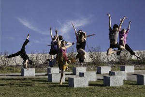 IMAGE A group of dancers jump into the air over concrete blocks. IMAGE