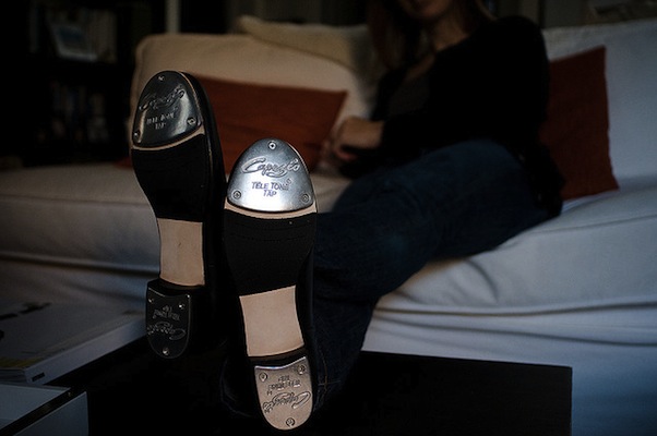 IMAGE Woman sits on a couch, displaying her new Capezio tap shoes. IMAGE