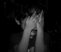 IMAGE A child covers his eyes, crying IMAGE