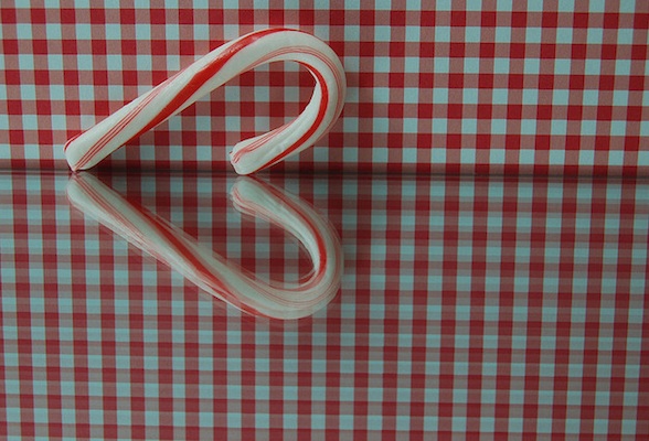 IMAGE A candy cane's tabletop reflection forms a heart. IMAGE