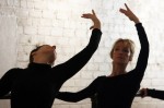 Adult ballet students perform cambré at the barre.