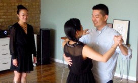 A wedding couple dance as teacher, Szewai Lee looks on.