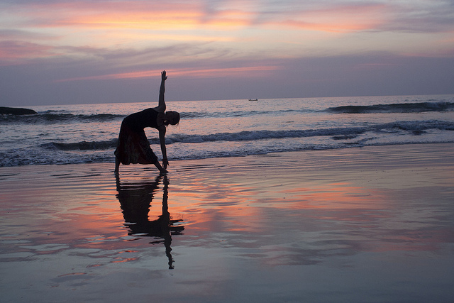Woman practicing yoga on beach