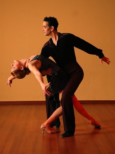 A male dancer dips a female ballroom dancer.
