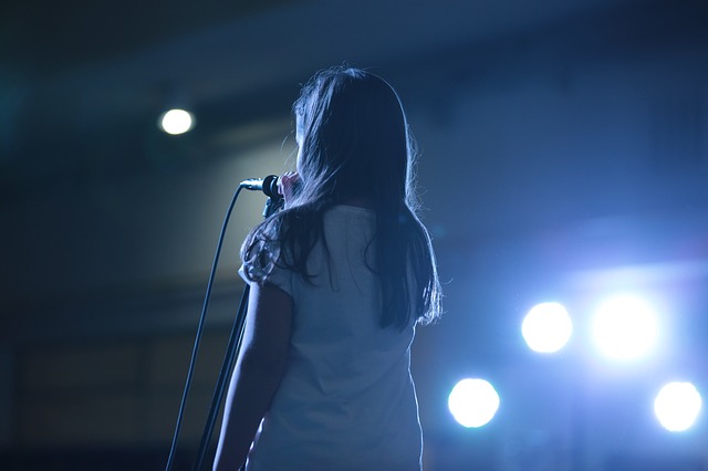 Girl singing on stage into a microphone